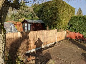 A boundary fence created using wooden panels and concrete posts and kick-boards.